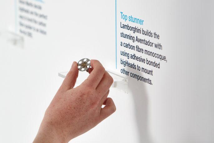 Close-up of a hand holding a bigHead product as part of a branded company timeline