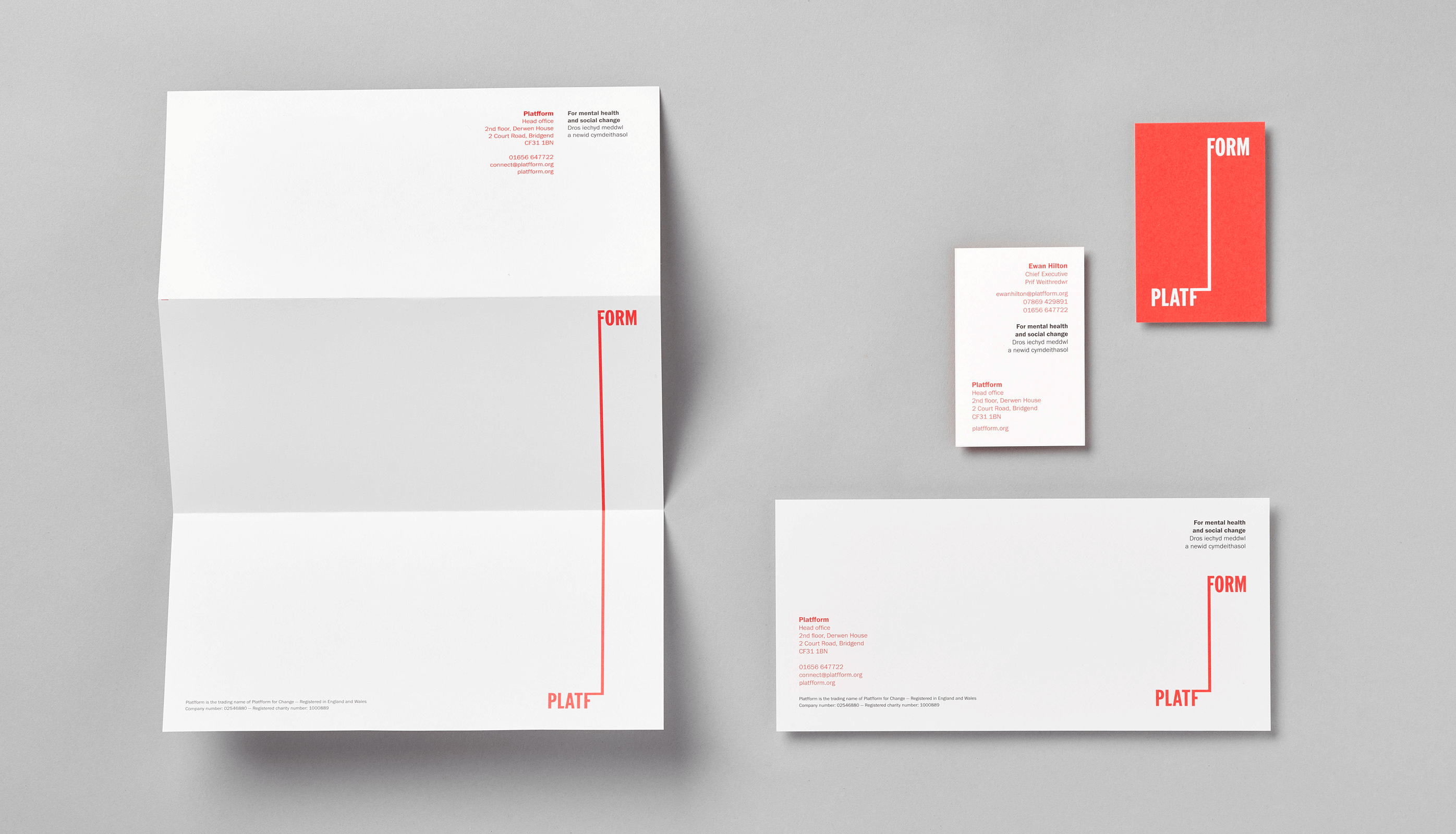 Branded letterhead, business card and compliments slip against grey background