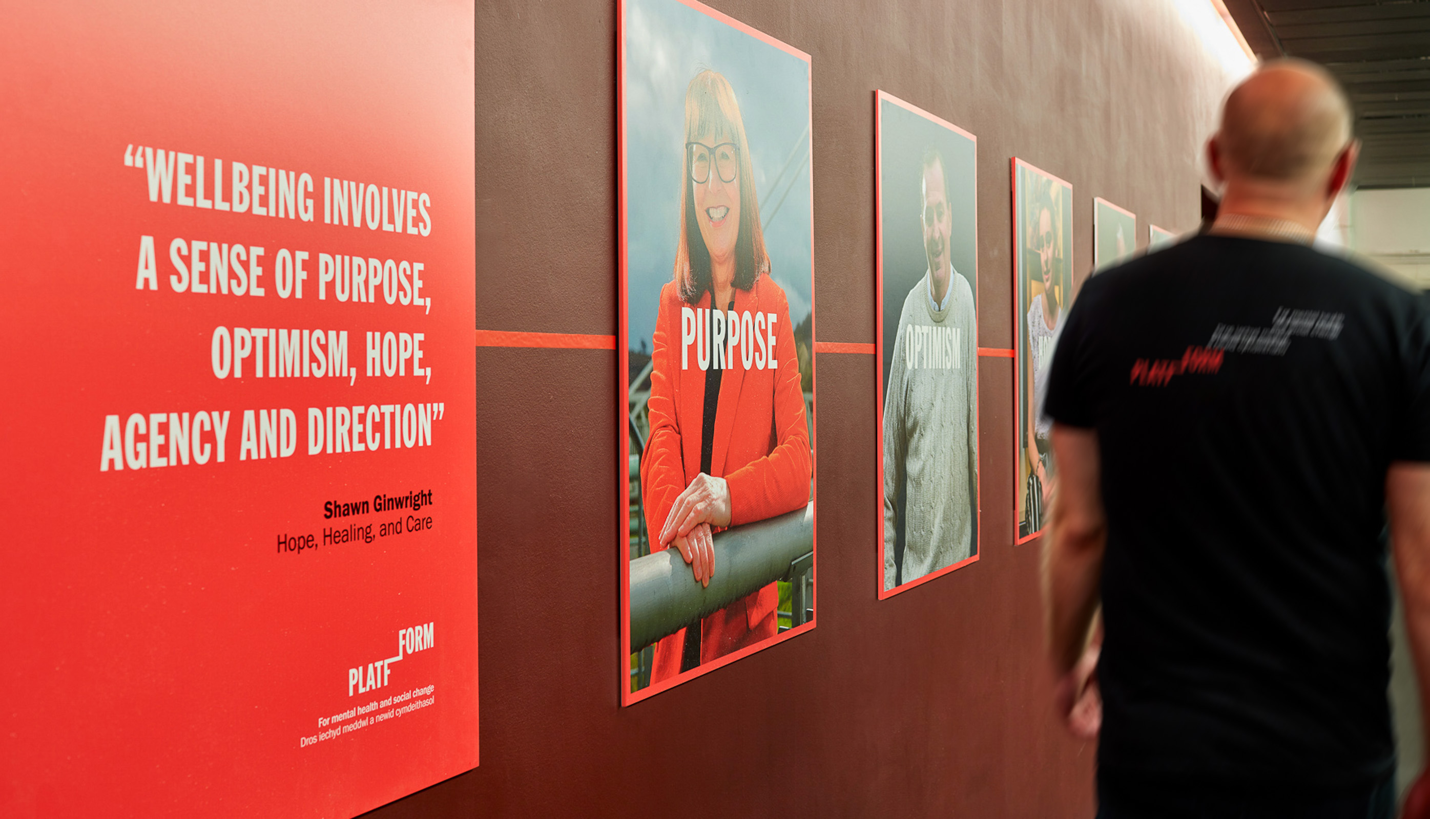 Series of inspirational posters along a wall showing charity message