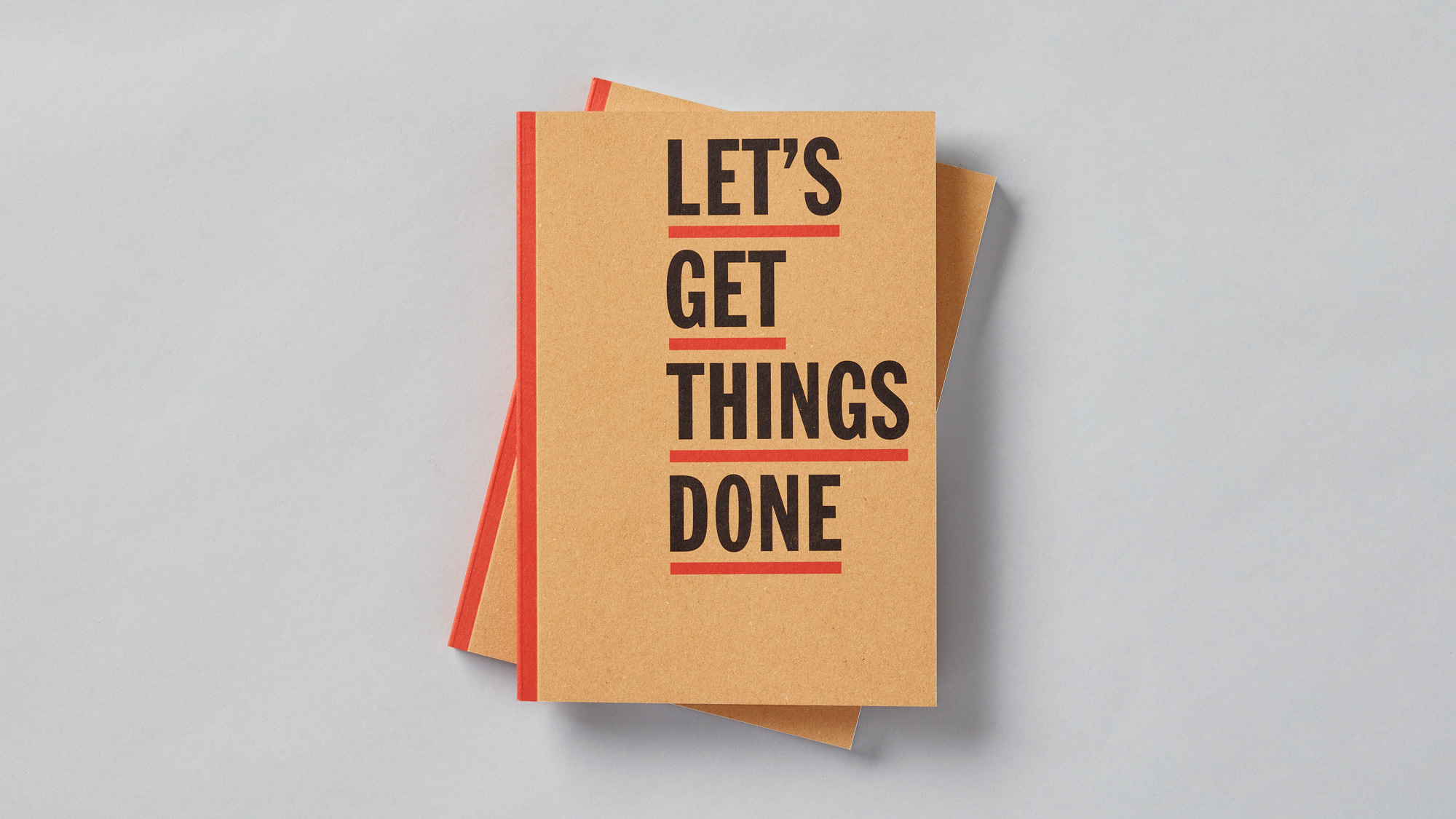 Image showing a stack of charity brand mental wellbeing journals sat on grey background