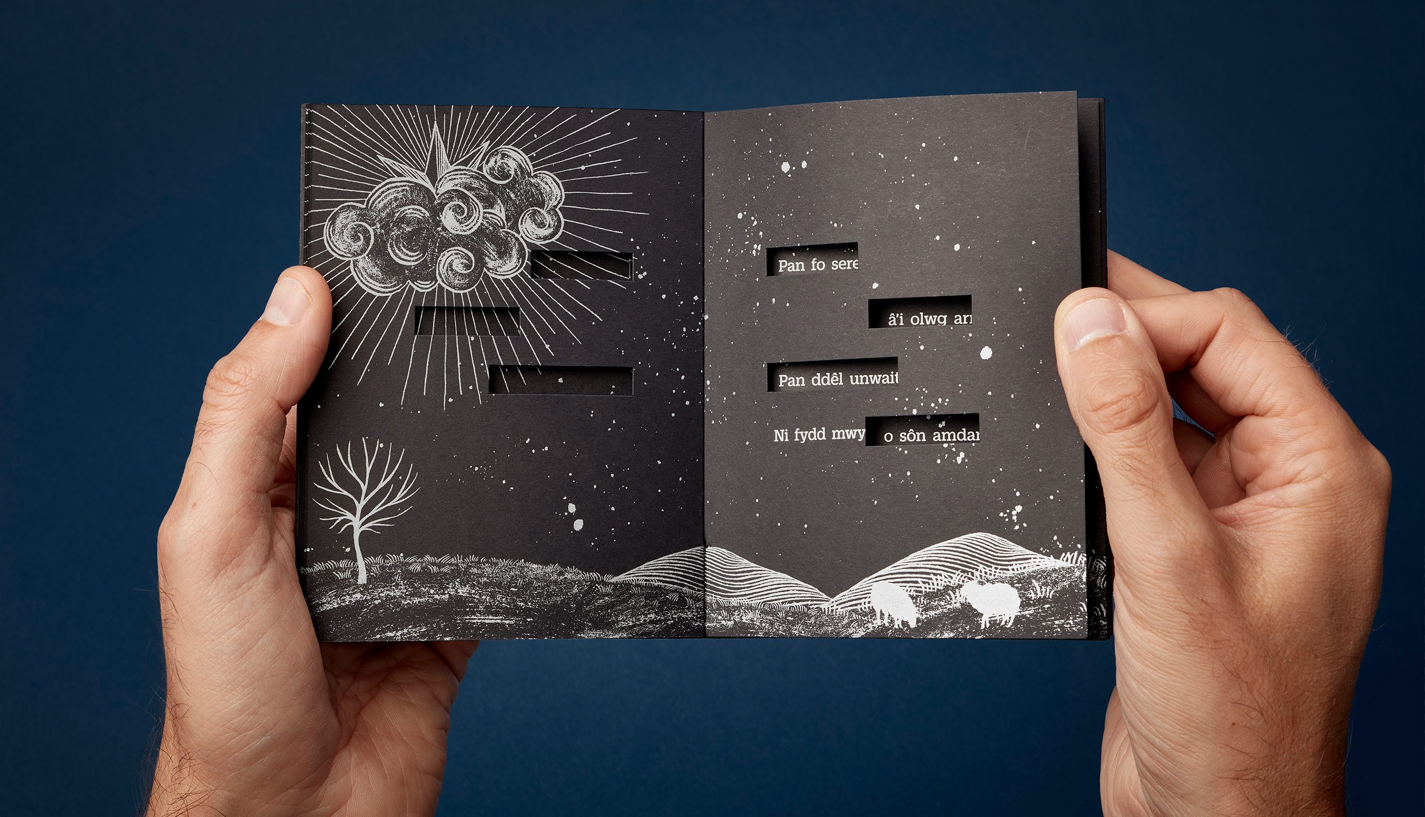 Poetry book spread showing die-cut windows that reveal words underneath