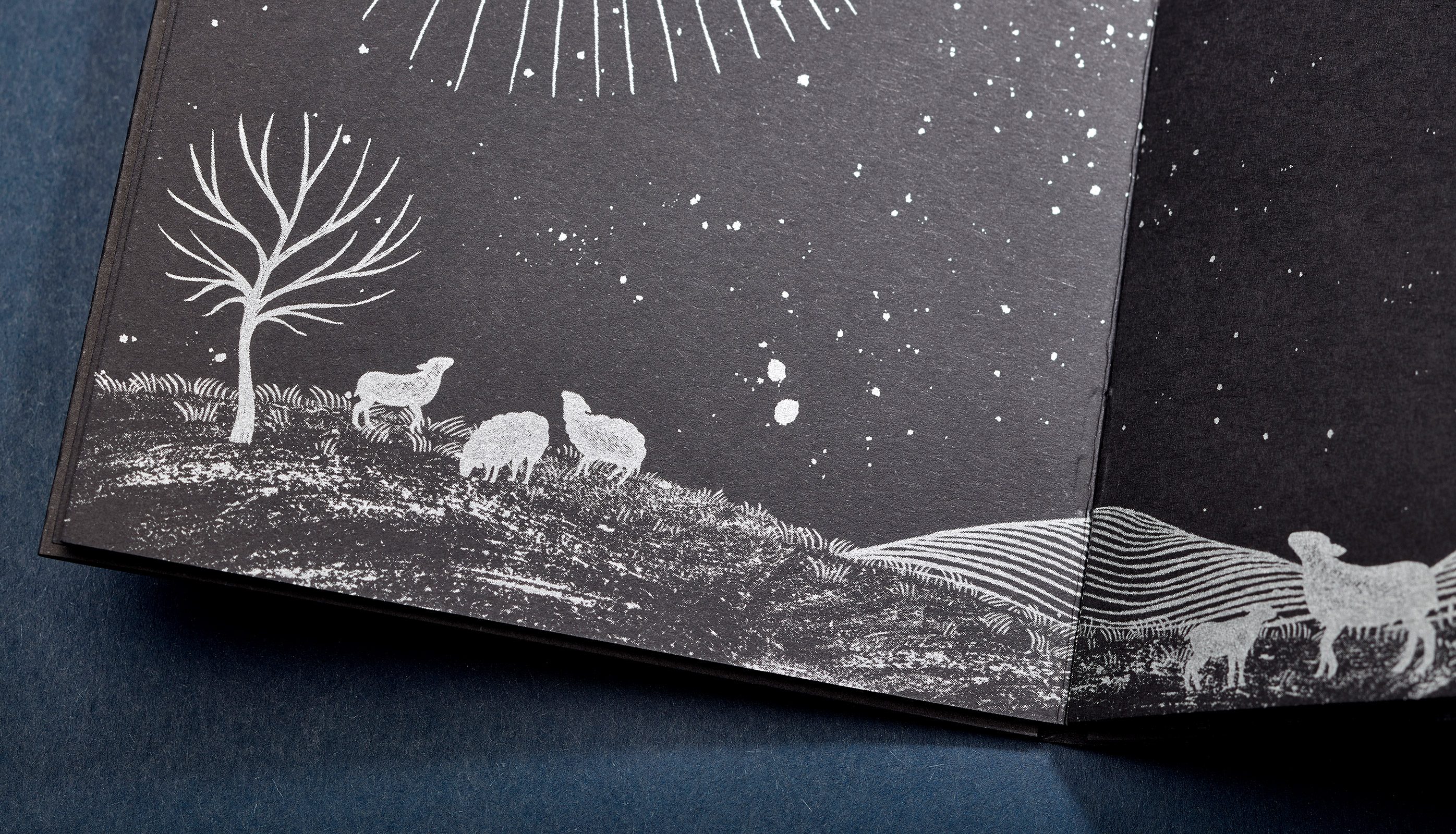 Close-up of poetry book page showing illustration of sheep on a cold, barren mountain