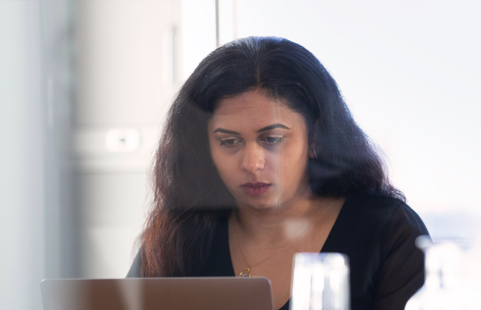Photo of woman staring at laptop in meeting room