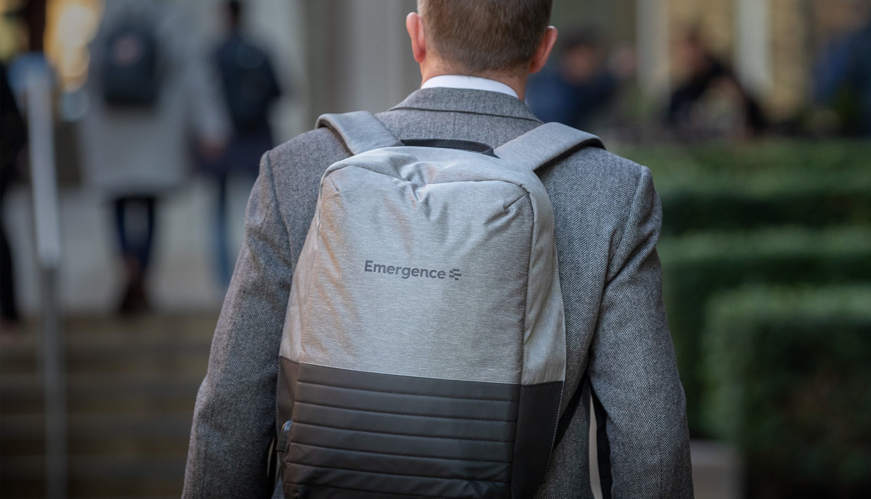 Image of back of suited business man with branded backpack