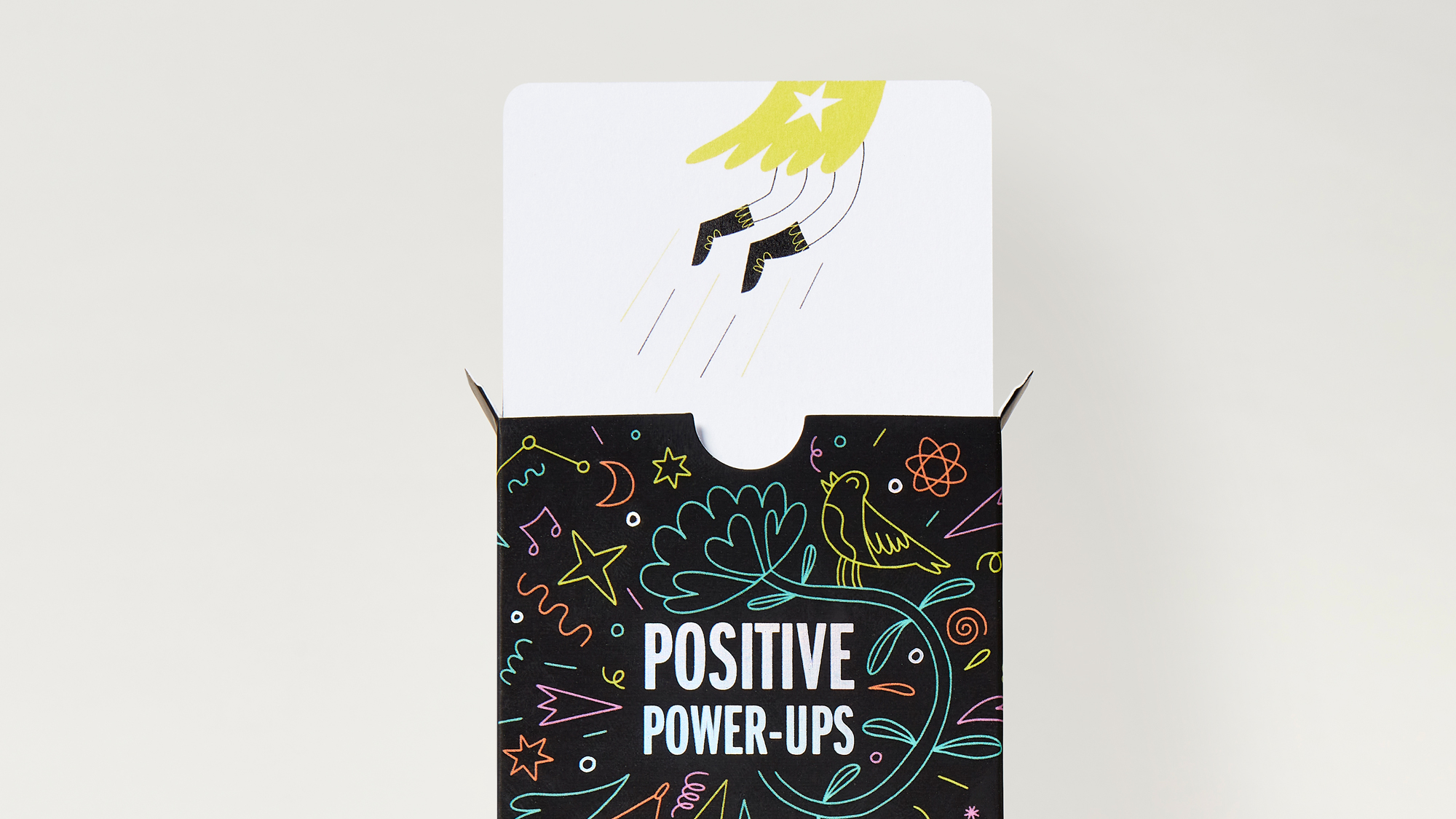 Front of card box with a card coming out of top showing illustration of a super hero flying off
