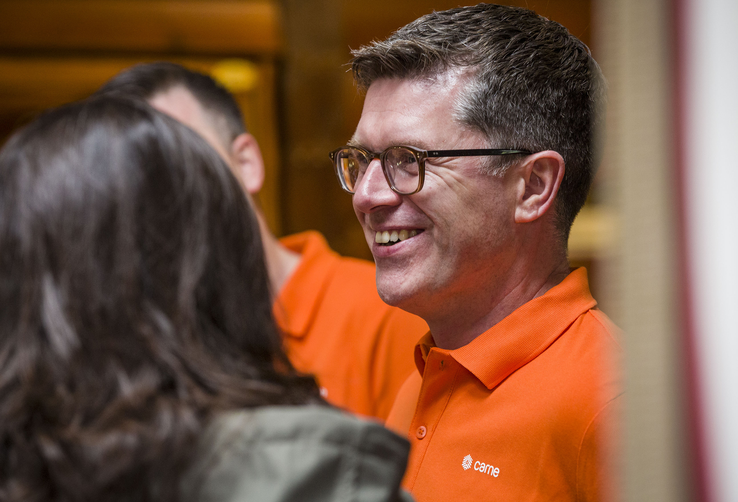 Man smiling at golf event wearing branded polo shirt